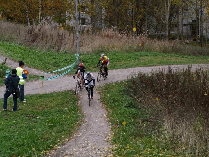 SM-cyclocross 2011 ajettiin Helsingin Kontulan Kelkkapuistossa 10.10.2010. Kuva on ensimmäiseltä kierrokselta, jossa naisten kärki on vielä yhdessä. Lähestytään kuitenkin juuri kilpailun ratkaisupaikkaa (kts. seuraava kuva).