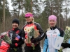 Jaana Hyvärinen sijoittui naisten maantie cupissa toiseksi. Kuvassa hän on Simon muistoajojen palkintopallilla myös kakkospaikalla tulevan maantiecupin voittajan Sini Savolaisen (CCH) tässäkin viedessä pidemmän korren. Kisan kolmospallilla muutamia vuosia aikaisemmin IK-32:ta edustanut Kirsi Väinölä (UP).